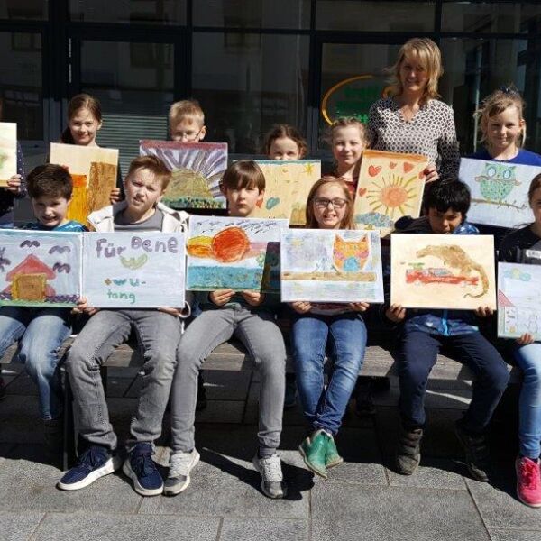 Die Kinder mit ihren kreativen Bildern auf Leinwand